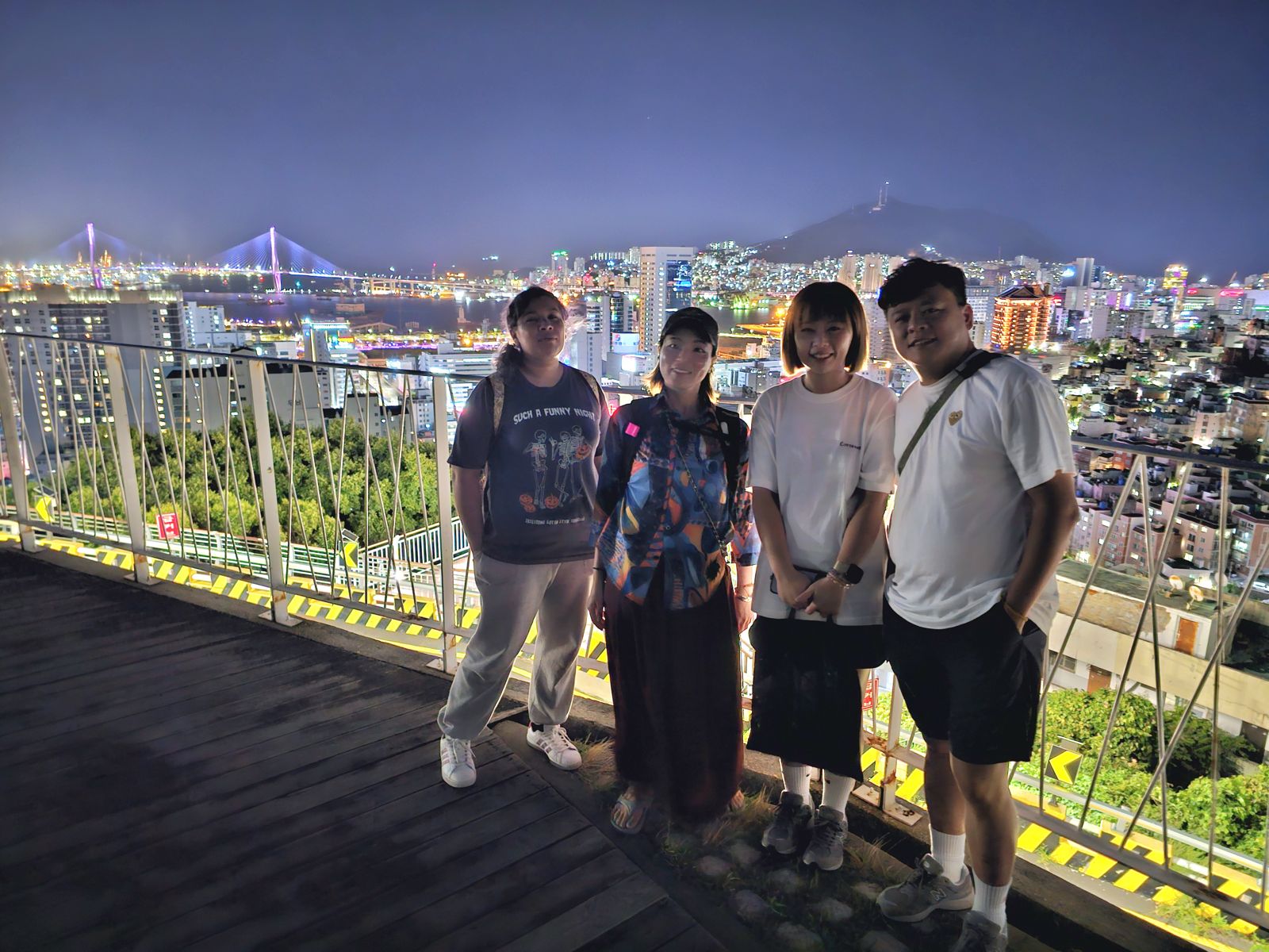 Viajeras con la vista nocturna de Busan y su puente iluminado